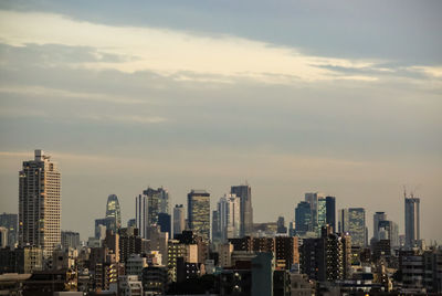 View of cityscape against cloudy sky