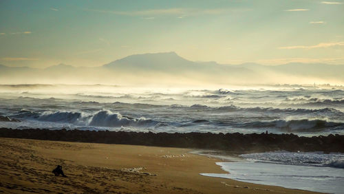 Scenic view of sea against sky during foggy weather on sunny day