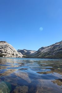 Scenic view of lake against clear blue sky