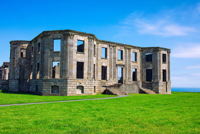 Old ruin on field against blue sky