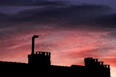 Low angle view of silhouette building against sky during sunset