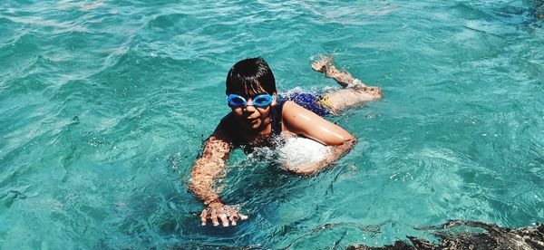 Portrait of young boy swimming in sea