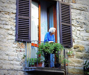 Low angle view of man outside house window
