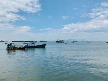 Fishing boats in sea against sky