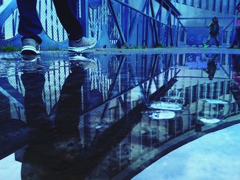 Reflection of man in puddle on lake