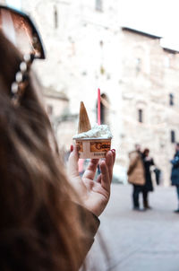 Close-up of woman holding ice cream in city