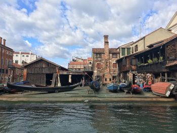 Canal amidst buildings in city against sky