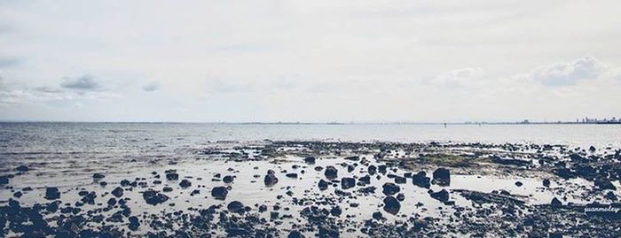 Scenic view of sea against cloudy sky