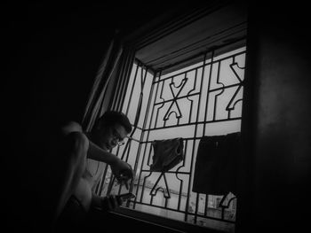 Side view of woman in glass window at home