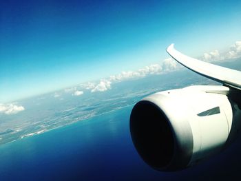 Close-up of airplane wing against blue sky