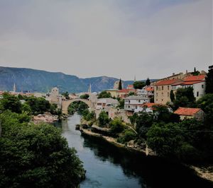 River amidst buildings in town against sky