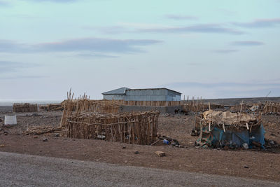 Abandoned hut on beach against sky