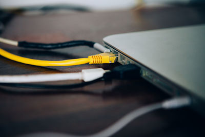 Close-up of computer cables connected to device on table