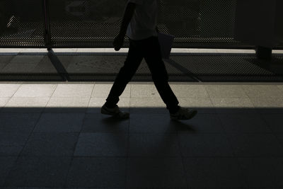Low section of woman walking on tiled floor