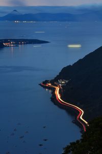 Light trail on street by sea