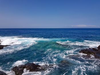 Scenic view of sea against clear blue sky