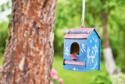 Close-up of birdhouse on wooden post