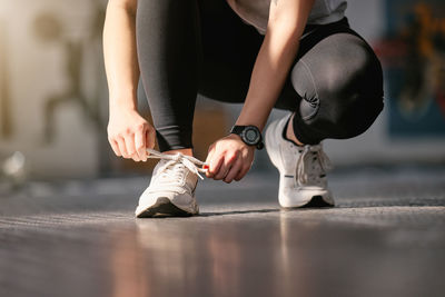 Low section of woman tying shoelace