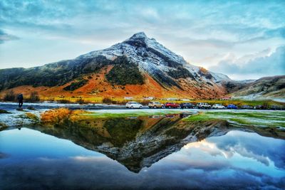 Scenic view of lake by mountains against sky