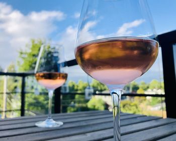 Close-up of wine glass on table against sky