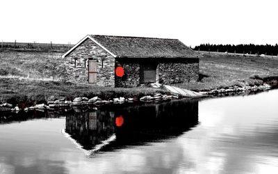 House by lake against clear sky