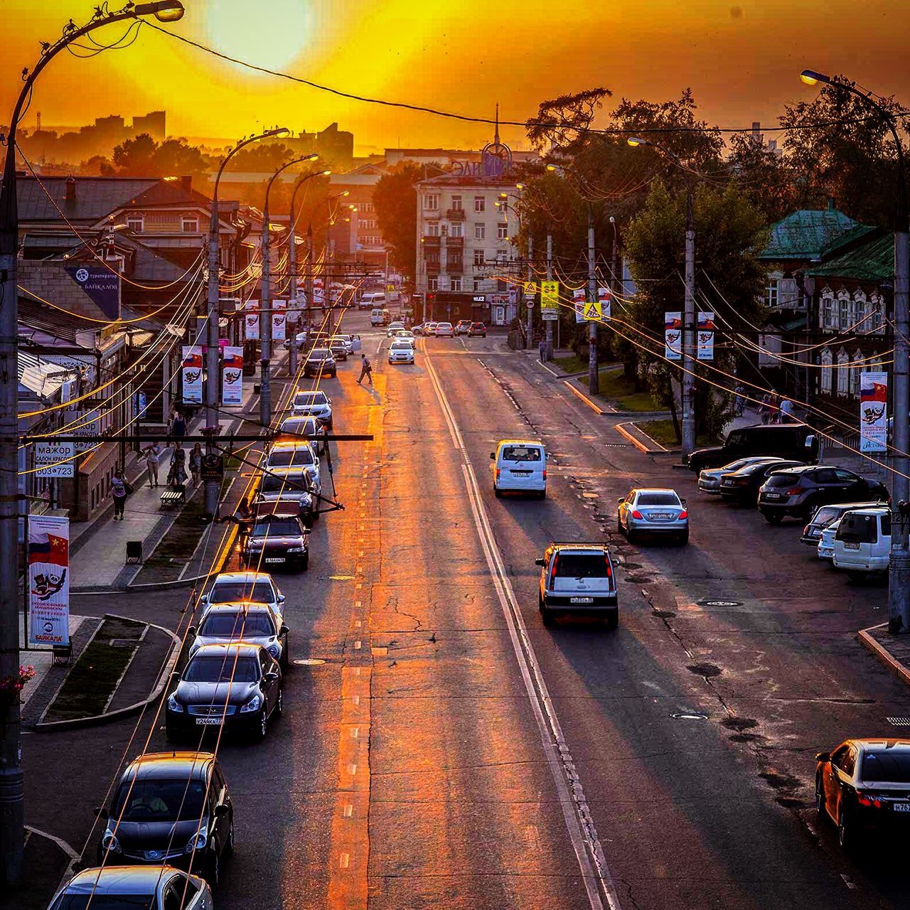 transportation, car, land vehicle, mode of transport, building exterior, architecture, street, built structure, city, traffic, road, sunset, the way forward, diminishing perspective, parking, city street, city life, incidental people, travel, tree