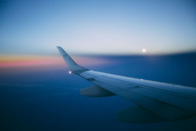 Airplane flying in sky during sunset