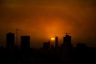Silhouette buildings against sky during sunset