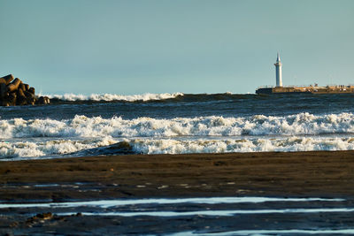 Sea by lighthouse against sky