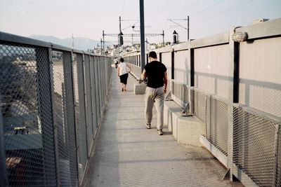 Rear view of men on bridge