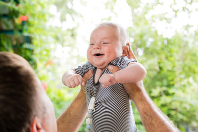 Father playing with son against trees