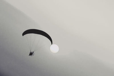 Low angle view of paragliding against clear sky