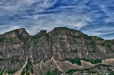 Low angle view of rocky mountains against sky