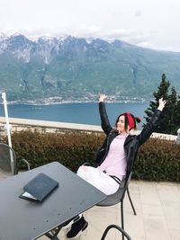 Woman relaxing against lake and mountains