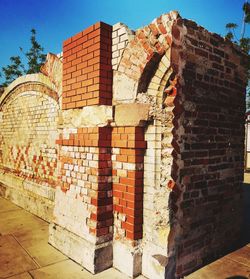 Low angle view of brick wall against building