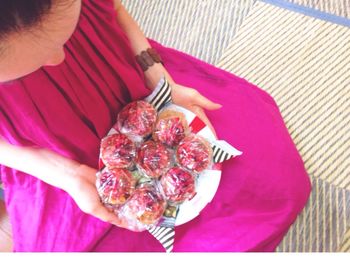 Cropped image of woman holding strawberries