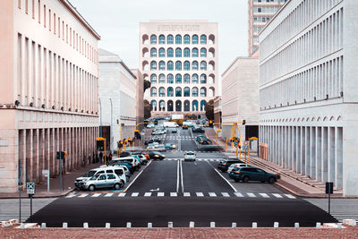 Vehicles on road amidst buildings in city