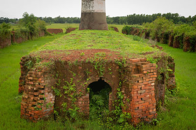 Built structure on field against trees