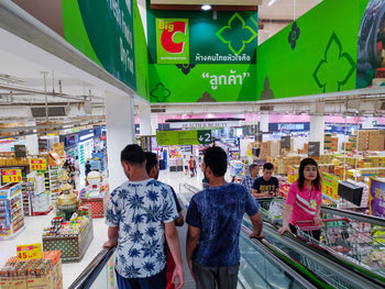 Rear view of people standing at store