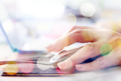 Close-up of human hand using mouse at desk