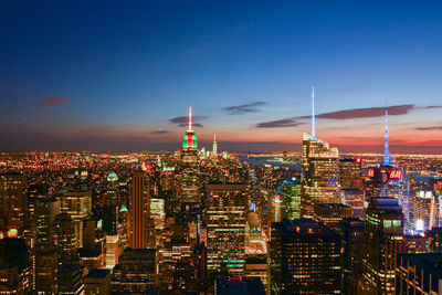 Illuminated cityscape against sky at night