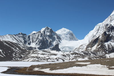 Scenic view of snowcapped mountains against clear blue sky