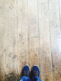 Low section of man standing on hardwood floor