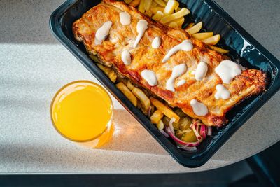 High angle view of pork ribs and fries and juice on table