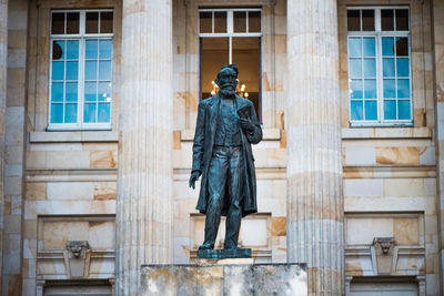 Rear view of a statue against building in city