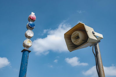 Low angle view of megaphone and lights against sky