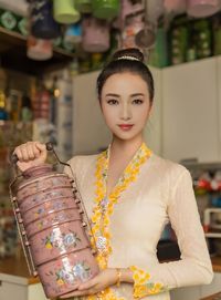 Portrait of young woman wearing kebaya standing in store