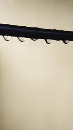 Close-up of water drops on metal against sky