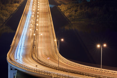 Highway at night lights. fast car light path, trails and streaks on interchange bridge road. night