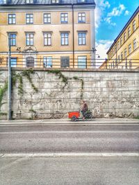 Road by building against sky in city